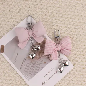 Cute stuffed fabric bow keychain with metallic heart pendants, stylish bag accessory charm.