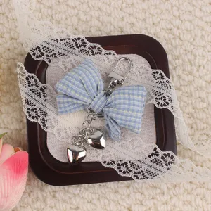 Blue striped fabric bow keychain with double heart metal charms, cute bag pendant accessory.