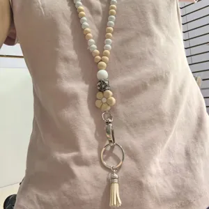 Cordino portabadge artigianale in perline di legno e silicone con fiore e nappina graziosa.