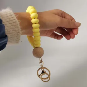 Detailed close-up of the yellow silicone bead and wooden bead wrist keychain clasp.