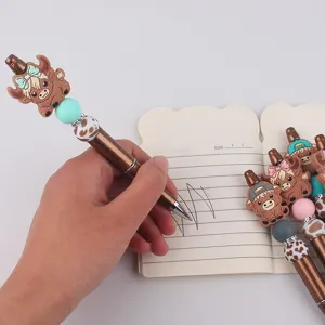 Close-up of DIY multi-color beaded pen with cute silicone yak topper and colorful beads for writing.