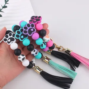 Silicone paw print beaded keychain detail, colorful beads and tassel pendant closeup view.