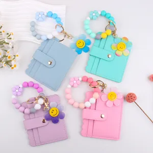 Detailansicht von bunten Silikonperlen Armband Kartenetuis mit süßen Smiley Blumen Anhängern.
