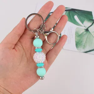 Mint green silicone beaded keychain with rhinestone spacers and disco ball charm for bags.