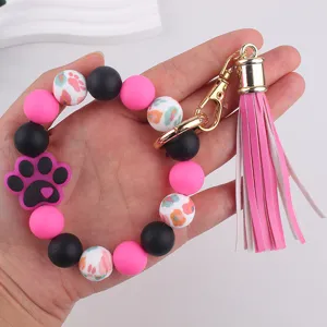 Silicone bead keychain detail view with pink black balls paw print charm and tassel