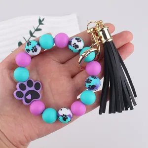 Silicone bead keychain bracelet featuring cute paw print charms and a stylish black tassel.