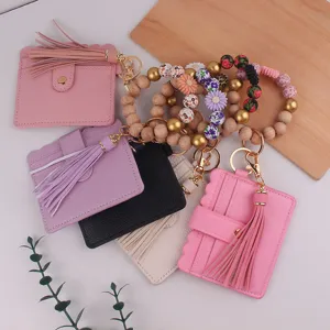 Vue détaillée du porte-clés bracelet en perles fait main avec étui de carte en cuir et pompon.