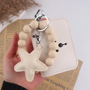 Portachiavi con braccialetto di perline in silicone beige con ciondoli stella e porta carte.