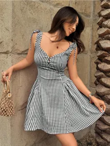 Chic black and white gingham mini dress with adjustable tie straps and flared skirt