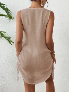 Detailed back view of a sheer tan cotton beach cover-up with side drawstring accents