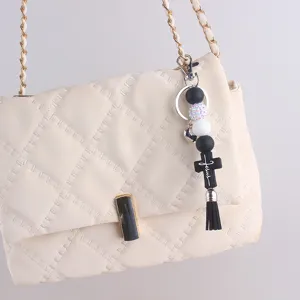 Silicone beaded cross tassel keychain bag charm, stylish black and white backpack pendant.