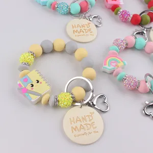 Silicone beaded keychain wristlet with cute charms and handmade leather tag pendant.