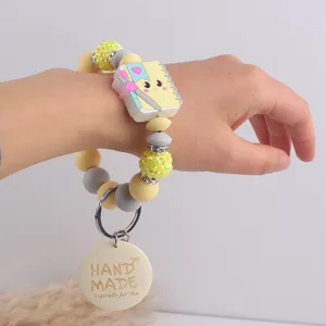 Silicone beaded bracelet featuring a cute notebook charm and handmade wooden tag keychain.