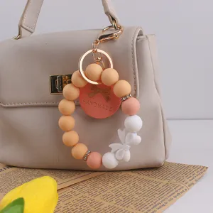 Silicone beaded keychain bracelet with bow and handmade tag, perfect gift for women and girls.