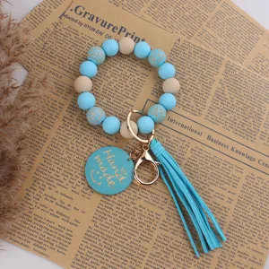 Plaque en bois smiley faite à la main porte-clés bracelet perles silicone avec pompon bleu.