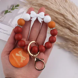 Handmade silicone beaded keychain bracelet with bow pendant, stylish accessory for women and girls.