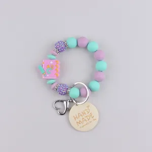Silicone bead keychain with notebook pendant and handmade tag for stylish daily decoration.