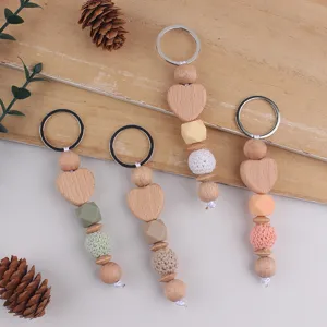 Detailed view of handmade wooden heart keychain with silicone and yarn crochet beads.