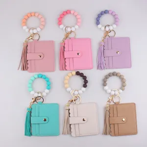 Vue détaillée de porte-clés en perles de silicone avec étuis à cartes en cuir PU et glands.