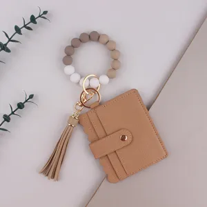 Porte-clés bracelet en perles de silicone avec étui à cartes en cuir et gland détail.