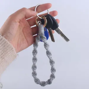 Dettaglio portachiavi intrecciato in cotone grigio fatto a mano con anello dorato lucido.
