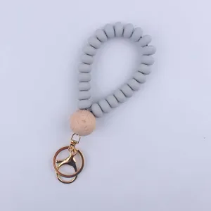 Silicone bead wristlet keychain with natural wood bead and gold metal clasp for keys.