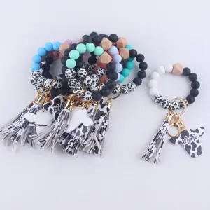 Silicone beaded keychain detail featuring cow print tassel and Mama pendant charm.