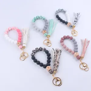 Detail view of colorful silicone beaded wristlet keychains with tassels and wooden evil eye beads.