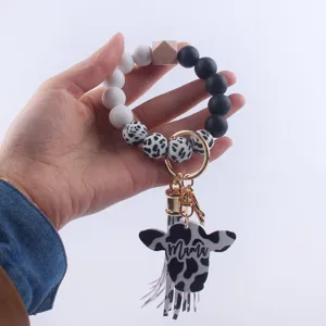 Silicone bead keychain bracelet with cow head pendant and tassel, black and white western style.