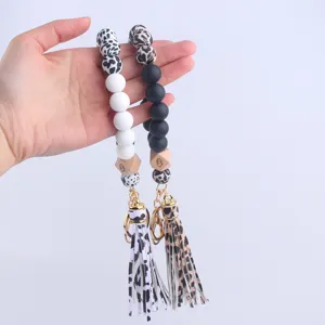 Silicone beaded wristlet keychain with wooden eyes charms, leopard print and black white beads.