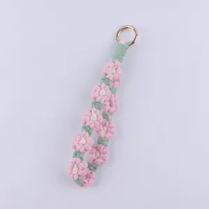 Handmade floral crochet keychain detail, cute pink and green daisy macrame strap design.