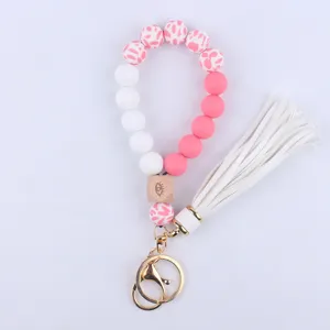 Silicone beaded wristlet keychain with evil eye wood bead, tassel and gold hardware.