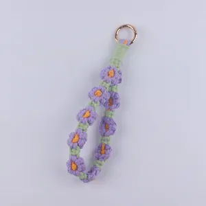Handmade crochet daisy keychain detail, purple cotton flower lanyard with gold metal ring.