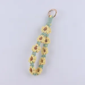 Close-up detail of the handmade macrame daisy keychain, showing delicate woven petal texture.