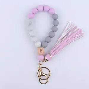 Silicone beaded wristlet keychain with wooden eye charm and leather tassel for keys.