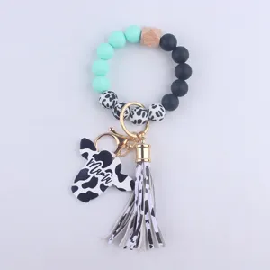 Silicone bead wristlet keychain with cute cow print, wooden bead and leather tassel charm.