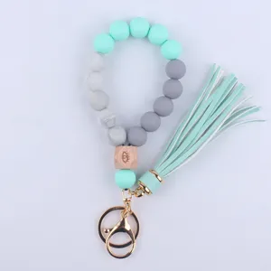Silicone beaded wristlet keychain detail with mint green grey beads and tassel charm.