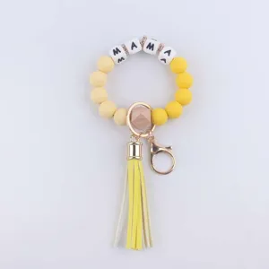 Silicone bead wristlet keychain with yellow tassel and letter beads detail view showcase.