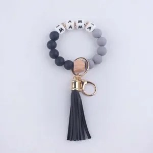 Stylish silicone bead keychain bracelet for women featuring black tassel and letter charms.