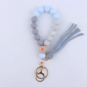 Silicone beaded wristlet keychain with wooden charm and leather tassel, ideal for daily use.