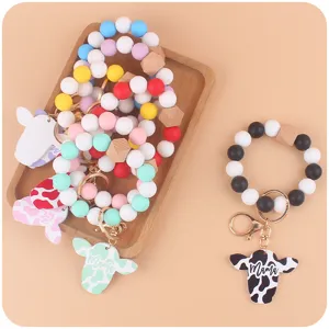 Silicone bead wristlet keychain showcasing cute cow head wooden pendant and metal clasp.