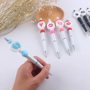 Detail shot of a creative DIY beaded ballpoint pen with cute silicone charms and metal body.