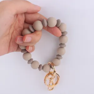 Detalle de llavero pulsera de cuentas de silicona con cuentas redondas y planas.