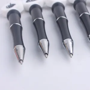 Detailed close-up view showcasing the fine metal tip and smooth black barrel of the DIY beaded pen.