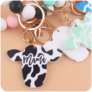 Silicone bead keychain detail showing cute cow pendant and metal ring accessory.