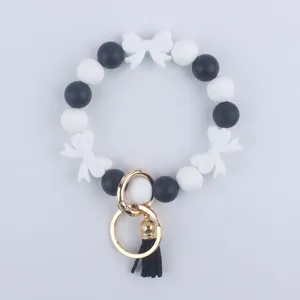 Portachiavi con braccialetto di perline in silicone nero e bianco con fiocchi e anello.