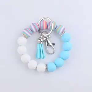Gros plan détail du porte-clés bracelet en perles de silicone avec rayures colorées et gland.