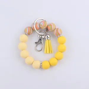 Détail de porte-clés en perles de silicone avec perles colorées, fermoir et pompon.