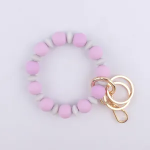 Pulsera llavero de cuentas de silicona con bloques violeta y gris y cierre dorado.