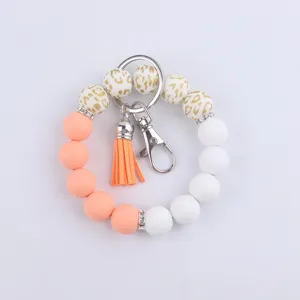 Vue détaillée du bracelet porte-clés en perles de silicone avec motif léopard et pompon.